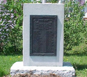 A stone monument with a plaque

Description automatically generated